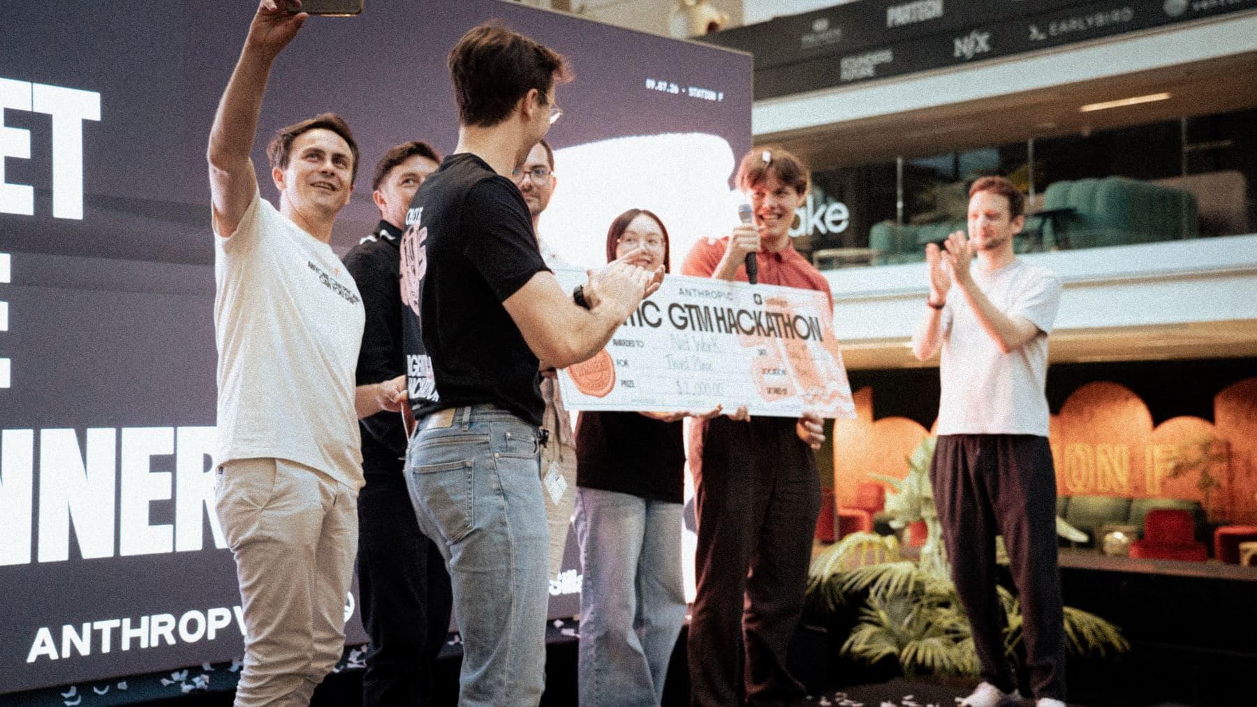 Winning team receiving its check on stage at Station F